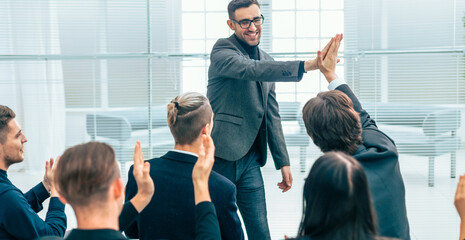 employees giving each other a high five during a work meeting