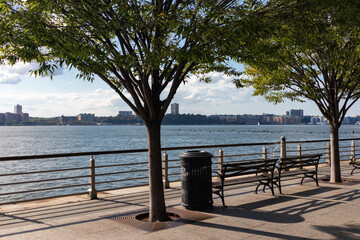 Fototapeta na wymiar New York City Riverfront along the Hudson River with Benches looking towards the Hoboken New Jersey Skyline
