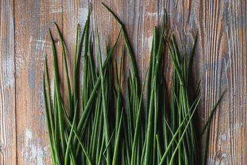 Spring green onion on wooden table, top view close up