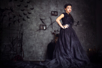 Fototapeta premium Halloween style girl in long black dress and crown
