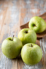 Granny smith organic apples close up on wooden rustic table for a grocery store catalogue