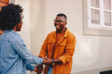 Young handsome african american hipster couple holding hands and being happy while standing on the street.