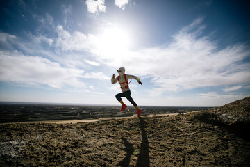 Woman trail runner cross country running  on sand desert dunes