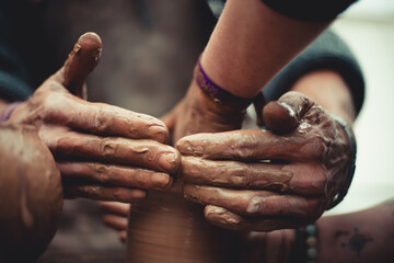 close up of hands on pottery wheel