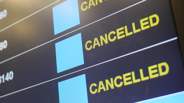 Time schedule digital board in airport terminal near check in counter. Cancelled flights. Preventive measures to reduce spread of disease during coronavirus pandemic