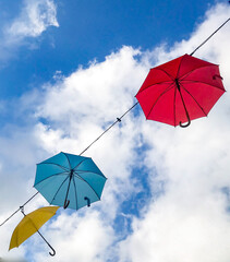 Colorful umbrellas hung in the air between the houses