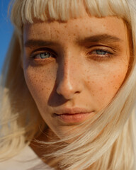 ?lose-up portrait of young blonde with blue eyes with freckles. Portrait of beautiful girl with...