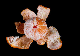 Peeled mandarine with a peel on a black background. Isolate on a black background.