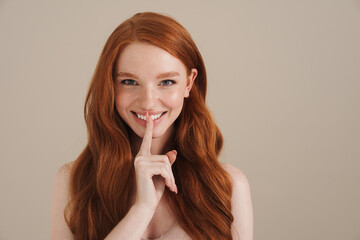 Photo of happy redhead shirtless girl showing silence gesture