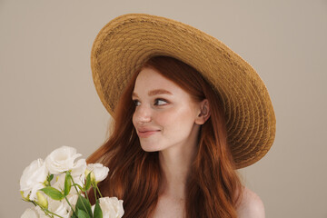 Photo of smiling redhead shirtless girl posing with white flowers