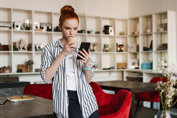 Beautiful young redheaded woman using mobile phone