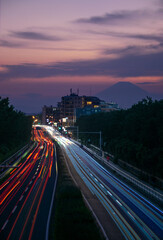 Long exposure of a highway with a mountain in the background.
