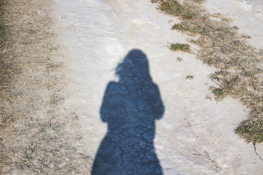 Silhouette of a girl on a chalk road.