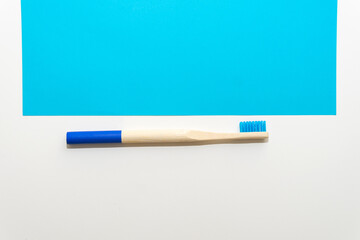 Bamboo toothbrush on a white and blue background Ecological and sustainable product concept. Eco friendly.