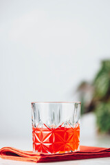 Glass of chocolate red orange negroni, an italian cocktail, an aperitif, first mixed in Firenze, Italy, in 1919, alcoholic bitter cocktail served on the light gray table