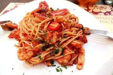 Italian pasta with seafood and tomatoes in restaurant