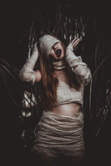 Portrait of beautiful asian sexy woman wear mummy costume in the forest,Horror movie...