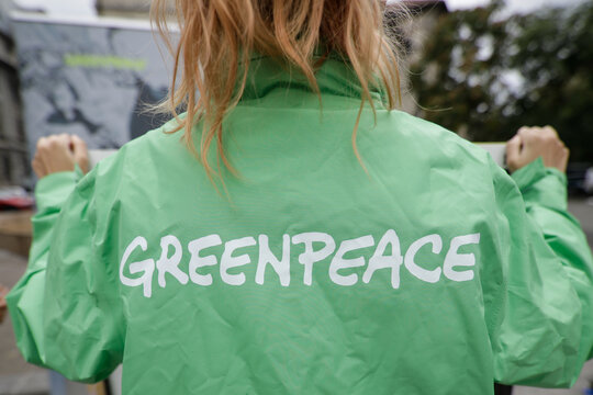 Greenpeace activist holding a banner at a protest.
