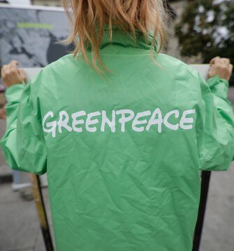 Greenpeace activist holding a banner at a protest.