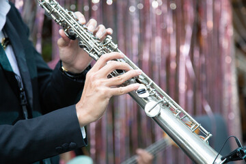 Clarinet player holding a metal transverse flute in his hands.