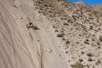 Extreme Rider climbing sand mountain on off-road cross enduro motorcycle