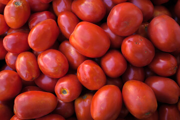 Background of red tomatoes that are sold in the open-air vegetable market.