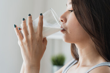 Healthy beautiful asian woman drinking plain fresh milk in the morning.