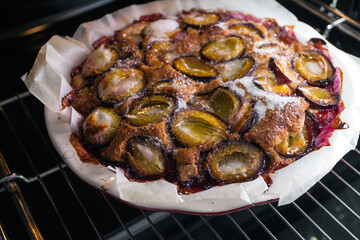 Freshly baked rustic plum cake at home in the oven in the kitchen. Homemade baking.