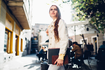 Female student walking in city on sunny day