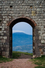 Fototapeta na wymiar Un arco del castello di Radicofani con il Monte Amiata sullo sfondo