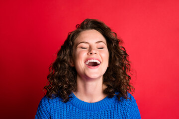 Photo of pretty cute lady curly hairstyle eyes closed laugh open mouth having fun crazy white smile wear blue knitted sweater pullover isolated red color background