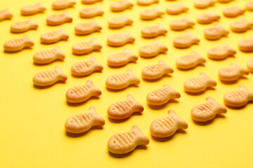 Obraz na płótnie Canvas Delicious goldfish crackers on yellow background, closeup