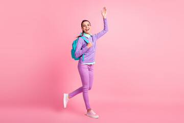 Fototapeta na wymiar Full length profile photo of pretty girl step raise hand wave wear specs backpack purple pullover pants sneakers isolated pink color background