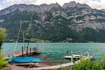 Yachts and boat on piers of alpine mountain lake.