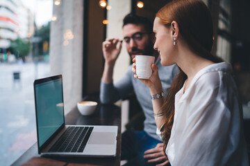 Young woman drinking coffee while remote working in cafe