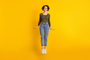 Full size photo of charming attractive girl jumping up isolated over vivid yellow color background