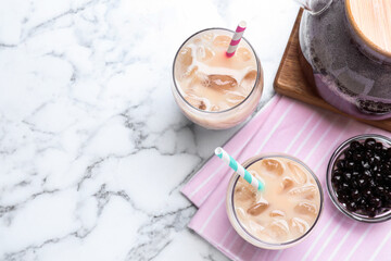 Bubble milk tea and bowl with tapioca balls on white marble table, flat lay. Space for text