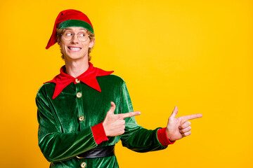 Portrait of his he nice attractive glad cheerful cheery funny guy elf showing copy space advert ad novelty gift present surprise isolated over bright vivid shine vibrant yellow color background