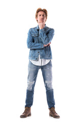 Skeptical young serious man with hand on chin staring at camera with distrust. Full body isolated on white background.