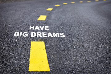 Have big dreams words on asphalt road surface with marking lines. Inspiration and motivation concept and effort idea