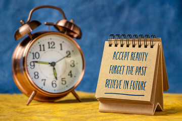 accept reality, forget the past, believe in future - inspirational note in a sketchbook with alarm clock, positive mindset and personal development concept