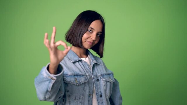 woman showing ok sign with fingers on green screen chroma key background
