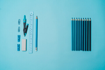 book, pencil, ruler on a blue background.