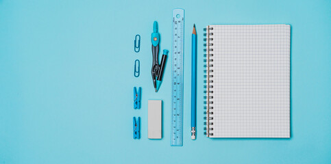 book, pencil, ruler on a blue background.