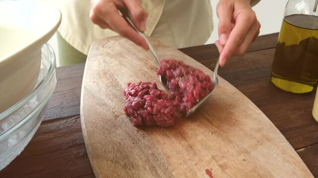 Crop female cook preparing Steak tartare