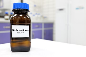 Selective focus of dichloromethane liquid chemical compound in dark glass bottle inside a chemistry...