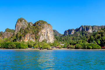 Fototapeta na wymiar Turquoise crystal clear sea water with limestone cliff and mountain at Railay East Beach, Krabi, Thailand