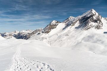 Obraz premium Snowshoes tracks on the gemmi pass near Leukerbad in Valais on a sunny winter day in Switzerland