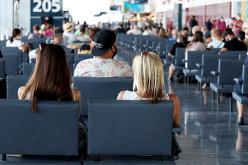 Passengers sitting in the airport terminal. People are waiting for their flight, travel concept	