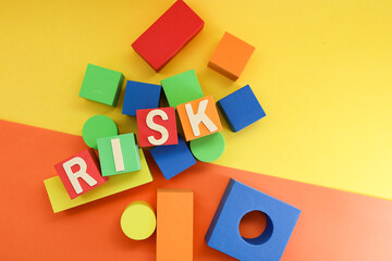 Block letters on risk on colorful cubes on yellow and orange background 